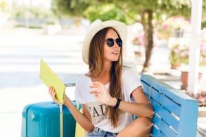 cute-girl-sitting-blue-bench-playing-tablet-yellow-case-768x512